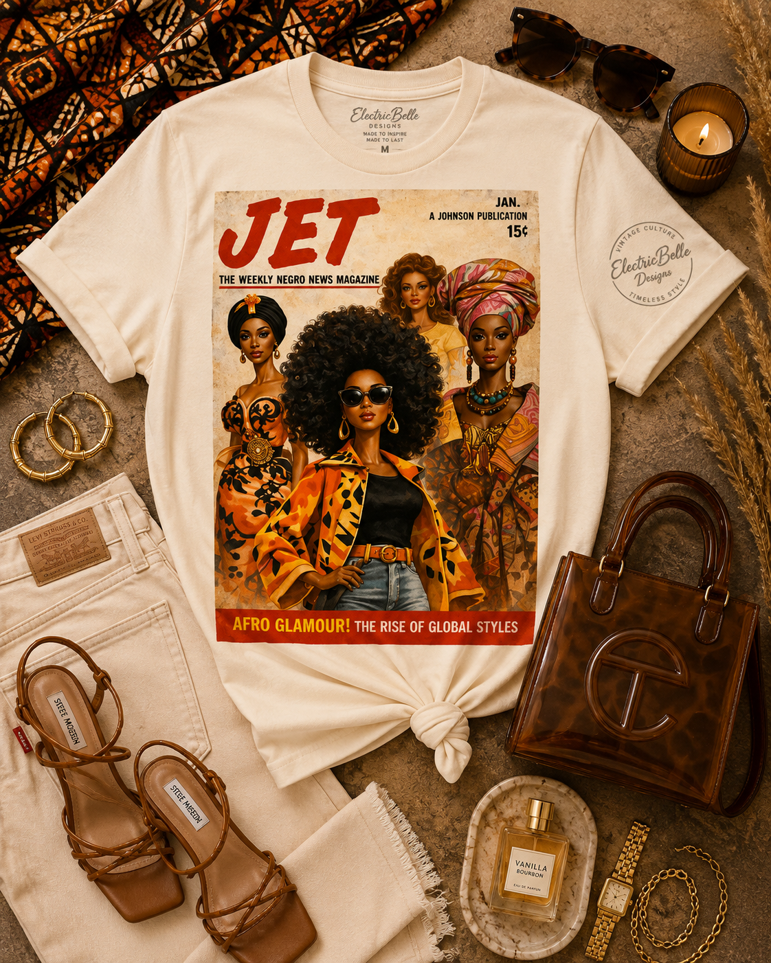 Soft cream Afro Glamour graphic tee styled with cream denim, brown strappy heels, a brown jelly bag, gold jewelry, tortoiseshell sunglasses and African print accents.