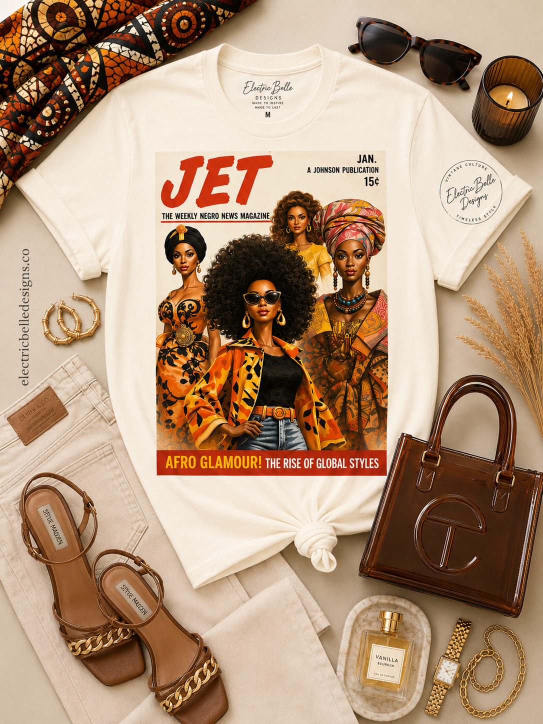 Flat lay of the JET Afro Glamour graphic t-shirt styled with cream trousers, a brown jelly bag, gold jewelry, strappy heels, tortoise sunglasses and African print accents for a modern chic vintage-inspired look.